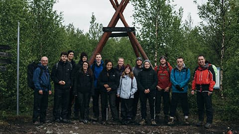 a group of people standing in a Swedish forest